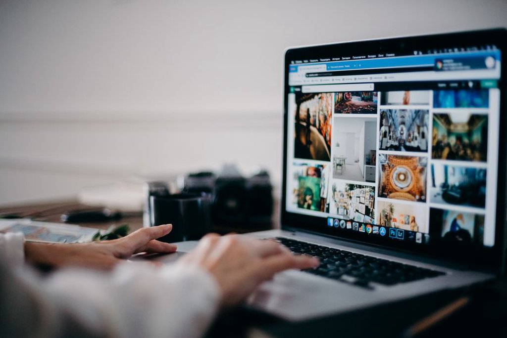 une cheffe d'entreprise parcourt une galerie d'images événementielles sur son ordinateur portable