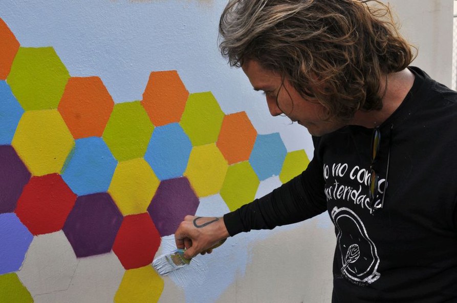 Artiste réalisant une composition murale géométrique