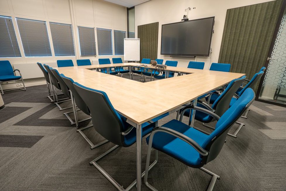 Tables disposées en U dans une salle lumineuse
